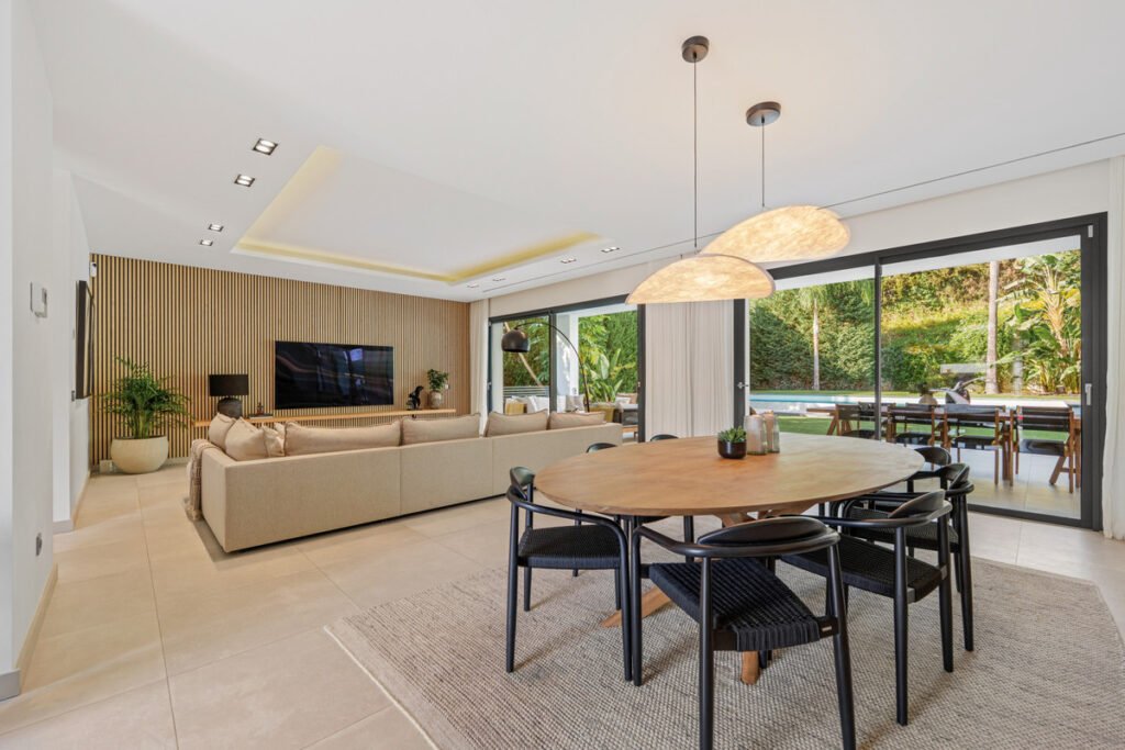 Modern luxury villa interior in Spain with open plan living room, dining area and garden view
